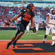 Running back Chuba Hubbard #30 of the Oklahoma State Cowboys scores on a 62-yard run against linebacker Garret Wallow #30 and defensive end Ochaun Mathis #32 of the TCU Horned Frogs on November 2, 2019 at Boone Pickens Stadium in Stillwater, Oklahoma. OSU won 34-27.